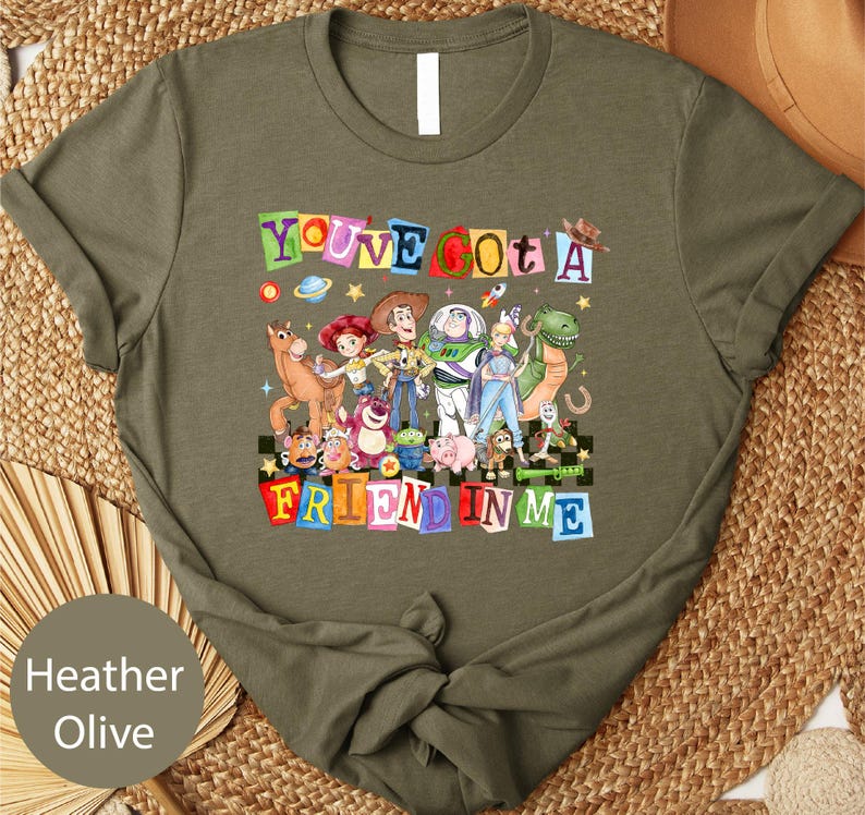 A t-shirt with a colorful graphic design featuring characters from the Toy Story franchise, including Woody, Buzz Lightyear, and other beloved characters.