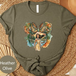 A t-shirt with a printed design featuring a woman with long hair and a yellow dress, surrounded by a colorful, abstract background.