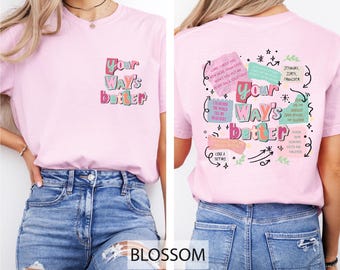 Puede incluir: Una camiseta rosa claro con el texto "Your Way's Better" en la parte delantera y trasera. El texto frontal está en una fuente colorida y juguetona. La parte trasera de la camiseta presenta texto y gráficos adicionales en un estilo similar.