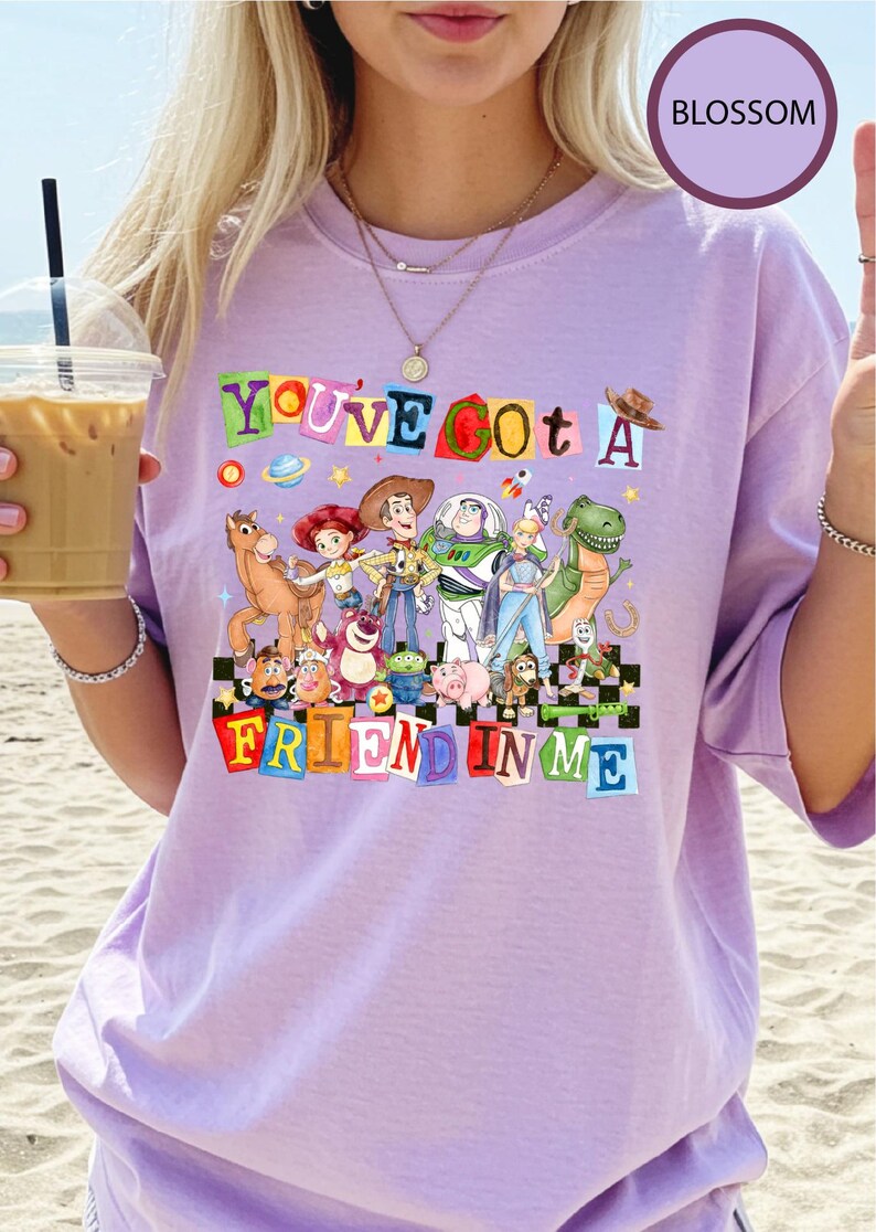 A woman wearing a purple t-shirt with a colorful graphic of characters from the Toy Story movie, including Woody, Buzz Lightyear, and other beloved characters.