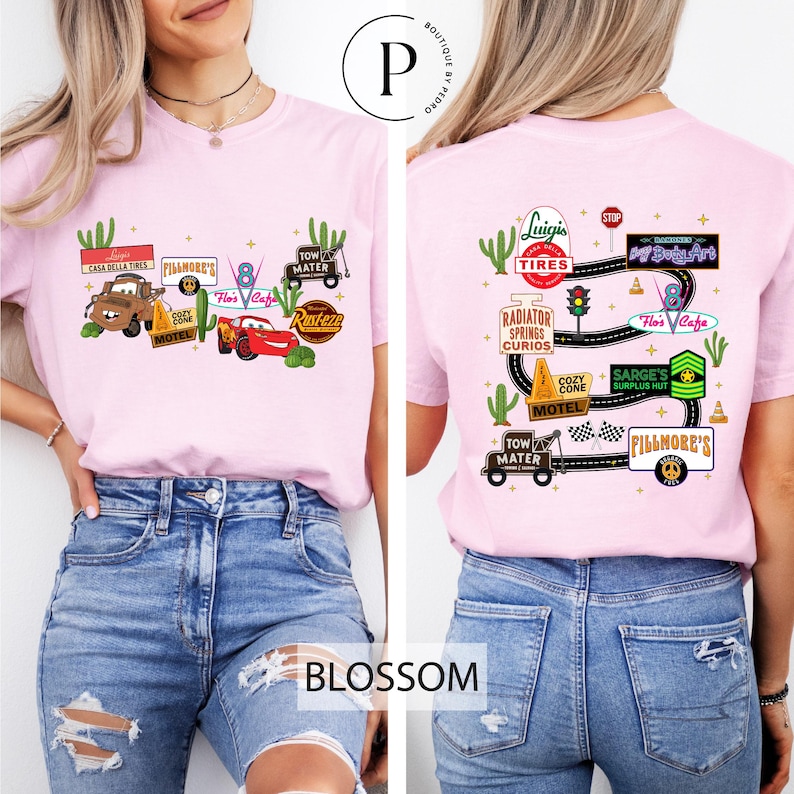 A woman wearing a pink t-shirt with various car-related graphics and text, including a pink car, a pink car with a tire, and a pink car with a tire.