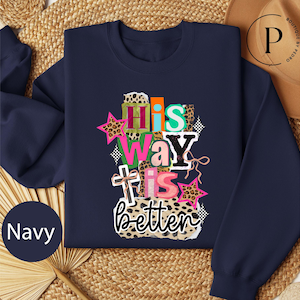 May include: Navy blue sweatshirt with the text "His Way Is Better" in a colorful, layered design. The design includes stars, a cross, and leopard print accents. The sweatshirt is a comfortable, casual style.