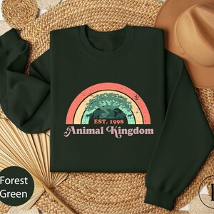 an animal kingdom sweatshirt with a rainbow in the background