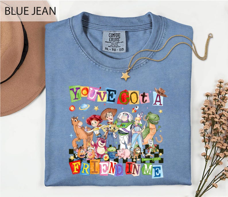 A blue t-shirt with a colorful graphic of characters from the Toy Story movie, along with the text "You've Got a Friend in Me" printed on it.