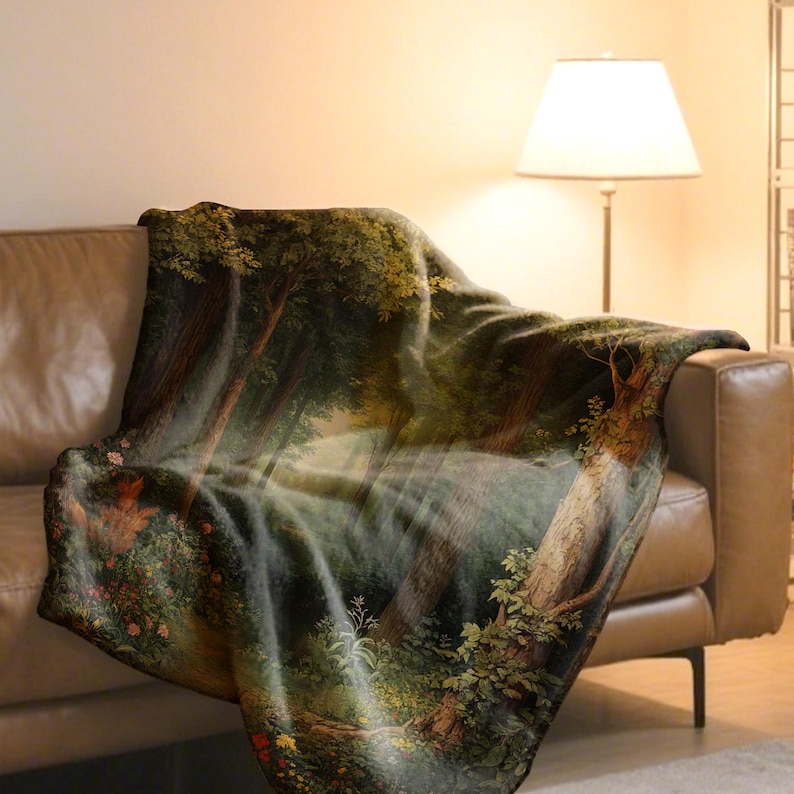 May include: A forest-themed throw blanket draped over a brown leather sofa. The blanket features a detailed painting of a lush forest with trees, foliage, and a waterfall. The color palette includes greens, browns, and hints of yellow.