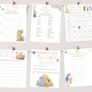 May include: A set of Winnie the Pooh baby shower game cards. The cards are white with gold and pink accents. The games include "Two Truths and a Lie", "What's in Your Bag", "Find the Guest Bingo", "Guess My Honey", "Don't Say Boy or Girl", and "What's the Baby Food".