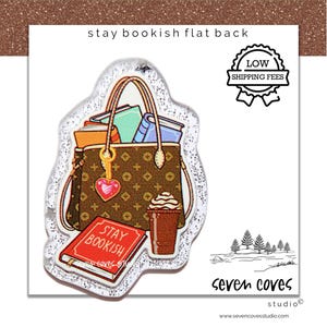 May include: A flat back charm with a bookish theme. The charm features a brown handbag filled with books, a red book with the text "Stay Bookish", and a coffee cup. A heart charm hangs from the handbag. The charm is outlined with glitter.