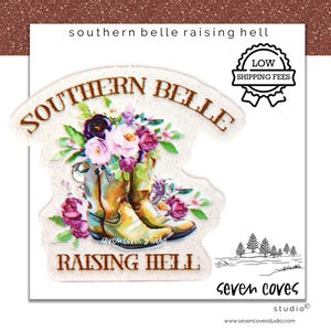 May include: A sticker featuring a pair of cowboy boots filled with flowers. The words "SOUTHERN BELLE" and "RAISING HELL" are arched above and below the boots. The sticker has a glittery finish and includes the text "southern belle raising hell".