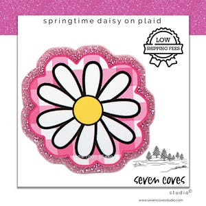 May include: A daisy design with white petals and a yellow center, set against a pink and white plaid background. The design is outlined with a glittery pink border. Text reads "springtime daisy on plaid".