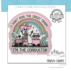 May include: A pink sticker with the text "I don't ride the crazy train, I'm the conductor." The design features a skeleton wearing a cowboy hat, a raccoon, a rainbow, and a pink train. The sticker also has a "Low Shipping Fees" badge.