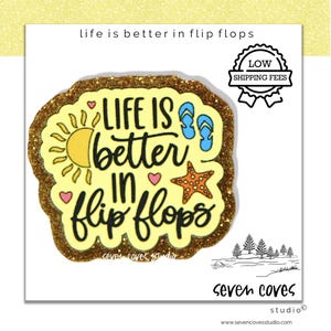 May include: A yellow and gold glittery sticker with the phrase "Life is better in flip flops." The design includes a sun, flip-flops, a starfish, and hearts. The sticker has a white background and a black outline.