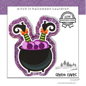 May include: A Halloween-themed sticker featuring a black cauldron with purple liquid and witch legs. The sticker has a glittery purple border and the text "witch in halloween cauldron". The sticker also has the text "Low Shipping Fees".