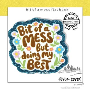 May include: A white sticker with a blue glitter border and the text "Bit of a MESS But doing my BEST" in brown lettering. The sticker is decorated with colorful flowers and green leaves. The sticker also has the text "seven coves studio".