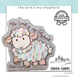 May include: A decorative, glitter-edged sheep illustration with the text "The Lord is my Shepherd" and "Psalm 23:1". The sheep has a pastel rainbow wool design and is set against a white background.