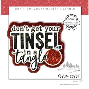May include: A festive holiday-themed graphic with the phrase "don't get your tinsel in a tangle" in black and white. The text is outlined in red glitter, with a red glitter ornament illustration. The image includes a "Low Shipping Fees" badge.