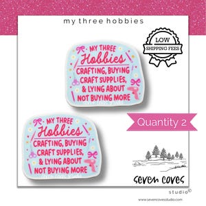 May include: Two light blue stickers featuring the text "MY THREE HOBBIES CRAFTING, BUYING CRAFT SUPPLIES, & LYING ABOUT NOT BUYING MORE" in pink and red. The design includes small illustrations of scissors, a glue gun, and bows on a light blue background.