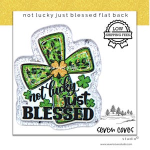 May include: A flat-back embellishment with a cross design, featuring green and gold accents, shamrocks, and the text "not lucky just BLESSED." The design includes a glittery border and a "Low Shipping Fees" badge.