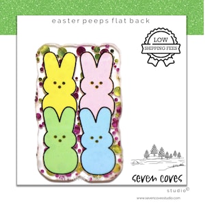 May include: Four colorful Easter Peep-shaped resin flatback embellishments. The Peeps are yellow, pink, green, and blue. The background is clear with pink and gold glitter.