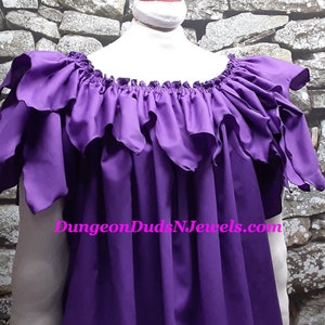 May include: A purple off-the-shoulder top with ruffled sleeves and neckline. The top is made of a smooth fabric and has a flowing design. The text "DungeonDudsNJewels.com" is visible at the bottom.