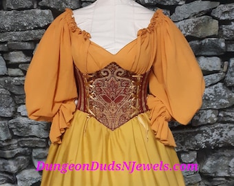 May include: A Renaissance-style dress on a mannequin. The bodice is a deep red with gold embroidery, and the sleeves are a vibrant orange. The skirt transitions from yellow to brown with layered ruffles. The website address is visible.