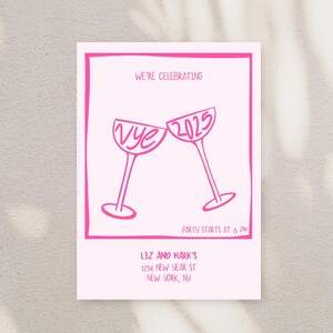 May include: Pink New Year's Eve party invitation with a graphic of two champagne glasses clinking. The glasses say "Vye" and "2025". The text reads "We're celebrating", "Party starts at 8 PM", "Liz and Mark's", "1234 New Year St", "New York, NY".