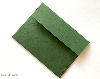 May include: A dark green envelope made of textured paper.
