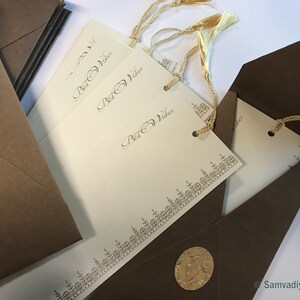 May include: A set of ivory-coloured cards with gold trim and the words "Best Wishes" printed on them. The cards are packaged in brown envelopes with gold seals.