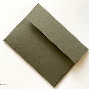 May include: A dark green envelope with a textured surface.