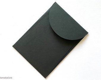 May include: A black envelope with a rounded flap. The envelope is made of a thick, textured paper.