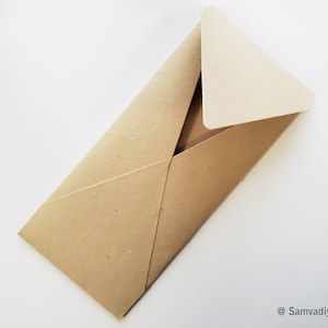 May include: A brown paper envelope with a white paper flap. The envelope is folded and ready to be sealed.