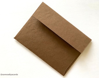 May include: A brown envelope with a textured surface, slightly open to reveal the interior. The envelope is set against a white background. The brand name "@samvadiyacards" is visible in the bottom left corner.