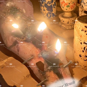 May include: A beef tongue spell candle featuring a pinkish-red tongue shape pierced by metal nails, with three lit candle flames emerging from the top. The text "Shut Your Mouth Beef Tongue Spell" is printed in the lower right corner of the image.