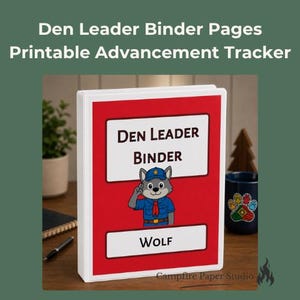 May include: A white three-ring binder with a red cover insert featuring a cartoon wolf character in a blue uniform saluting. The text reads Den Leader Binder and Wolf. The design includes white rectangular labels for the title and rank.