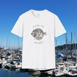 May include: White t-shirt featuring a graphic of a halibut fish and the text "Just for the Halibut".