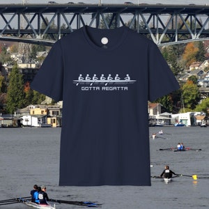 May include: A navy blue t-shirt with a white graphic of a rowing crew in a boat. The text "Gotta Regatta" is printed below the graphic.