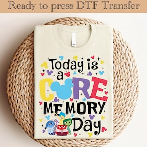 May include: A beige t-shirt with a colorful graphic design that says "Today is a CORE MEMORY Day" with a Mickey Mouse head in the middle of the word "CORE". The graphic also includes five characters from the movie Inside Out.
