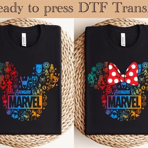 May include: Two black t-shirts with a rainbow Mickey Mouse design featuring Marvel characters and the text "Avengers Marvel".