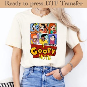 May include: A white t-shirt with a red, yellow, and blue graphic print of characters from the movie "A Goofy Movie". The graphic includes the text "A Goofy Movie" and "Est. 1995".