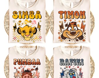 Könnte beinhalten: Vier weiße T-Shirts mit Bügelbildern, die Figuren aus dem Film Der König der Löwen zeigen. Die Shirts zeigen Simba, Timon, Pumbaa und Rafiki. Jeder Charakter ist in einem farbenfrohen Cartoon-Stil mit einem retro-inspirierten Design dargestellt.