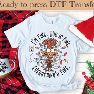 May include: Light blue t-shirt with a cartoon character tangled in Christmas lights. The character is saying "I'm fine. This is fine. Everything's fine."