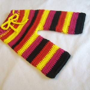 May include: Striped crocheted pants in black, red, yellow, and pink. The pants have a drawstring waist.