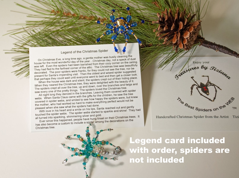 May include: A card featuring a blue and gold beaded spider ornament and a red beaded spider ornament. The card includes the text "Legend of the Christmas Spider" and "Enjoy your Treasures by Tiziana The Best Spiders on the WEB TM Handcrafted Christmas Spider from the Artist Tiziana". The card also has the text "Legend card included with order, spiders are not included".
