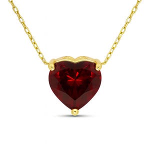 Può includere: Una collana dorata con un pendente a forma di cuore in pietra preziosa rosso scuro. Il pendente è incastonato in una lunetta dorata e pende da una delicata catena d'oro. La pietra preziosa a forma di cuore ha una superficie sfaccettata.