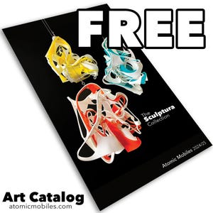 May include: A black art catalog with the word "FREE" in large white letters. The catalog features abstract sculptures in yellow, blue, and red. The catalog is titled "The Sculptura Collection" and includes the website atomicmobiles.com.