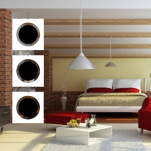 May include: A modern bedroom with a white bed frame, red pillows, and a beige blanket. The room has a white ceiling with wooden beams, a white lamp hanging from the ceiling, and a white wall with three circular cutouts.