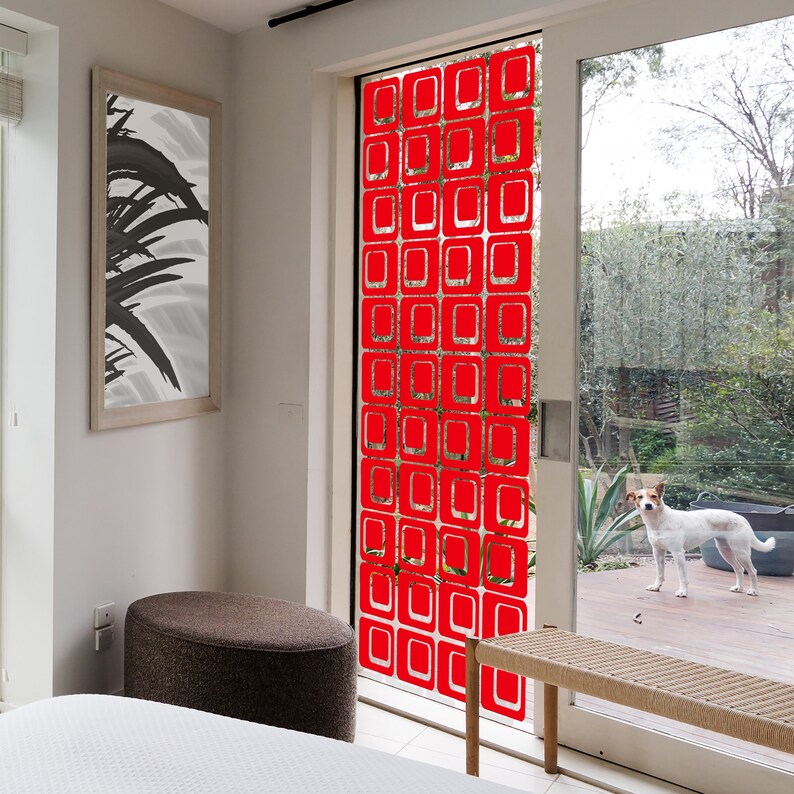 May include: A red geometric pattern window film with a repeating square design. The film is applied to a glass door leading to a backyard.