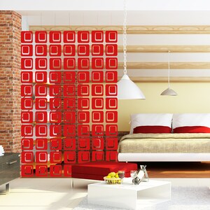 May include: Red room divider with a geometric pattern of squares. The divider is made of wood and has a modern design. It is shown in a room with a bed and a coffee table.