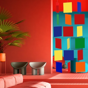 May include: A red room with two gray stools and a pink couch. A wall in the room has a blue background with a colorful geometric mobile hanging from the ceiling. The mobile is made of squares in various colors, including red, yellow, blue, green, and orange.