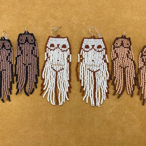 May include: Six pairs of beaded earrings with a fringe design. The earrings are in various colors, including brown, black, and white.