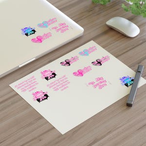 Op de afbeelding: Een vel papier met verschillende stickers met een roze hart met de tekst "All Couples to Mother" en een blauw hart met de tekst "All Couples to Mother". Er zijn ook stickers met een zwart en roze beeld van een open haard met de tekst "Eternal Summer Era" en de tekst "In My Nursing Era".